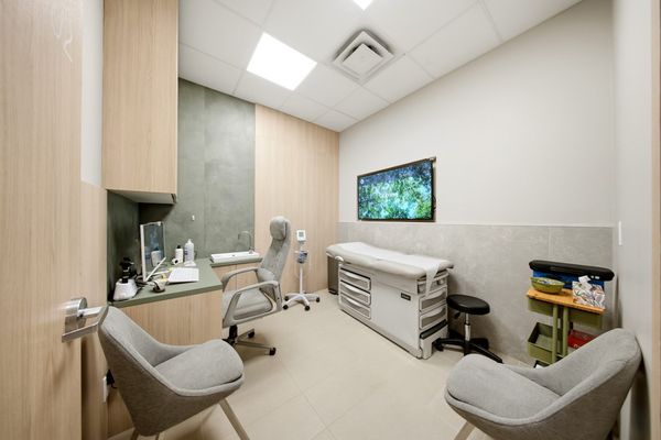 Exam room with oak millwork and a sage tile wall