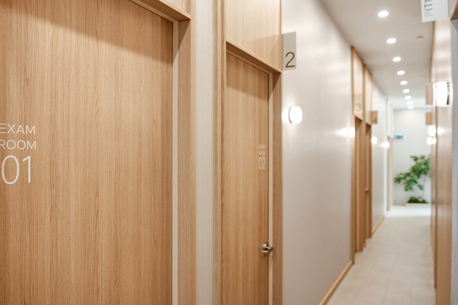 Oak exam-room doors signed Exam Room 01 and 02