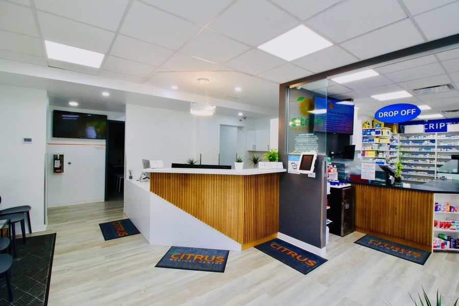 Clinic reception desk in wood beside a pharmacy counter